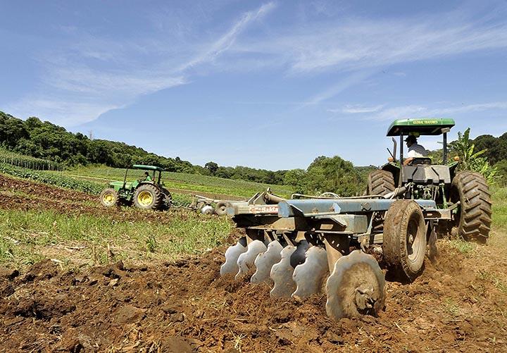 Trator compacto trabalhando em pequena propriedade rural