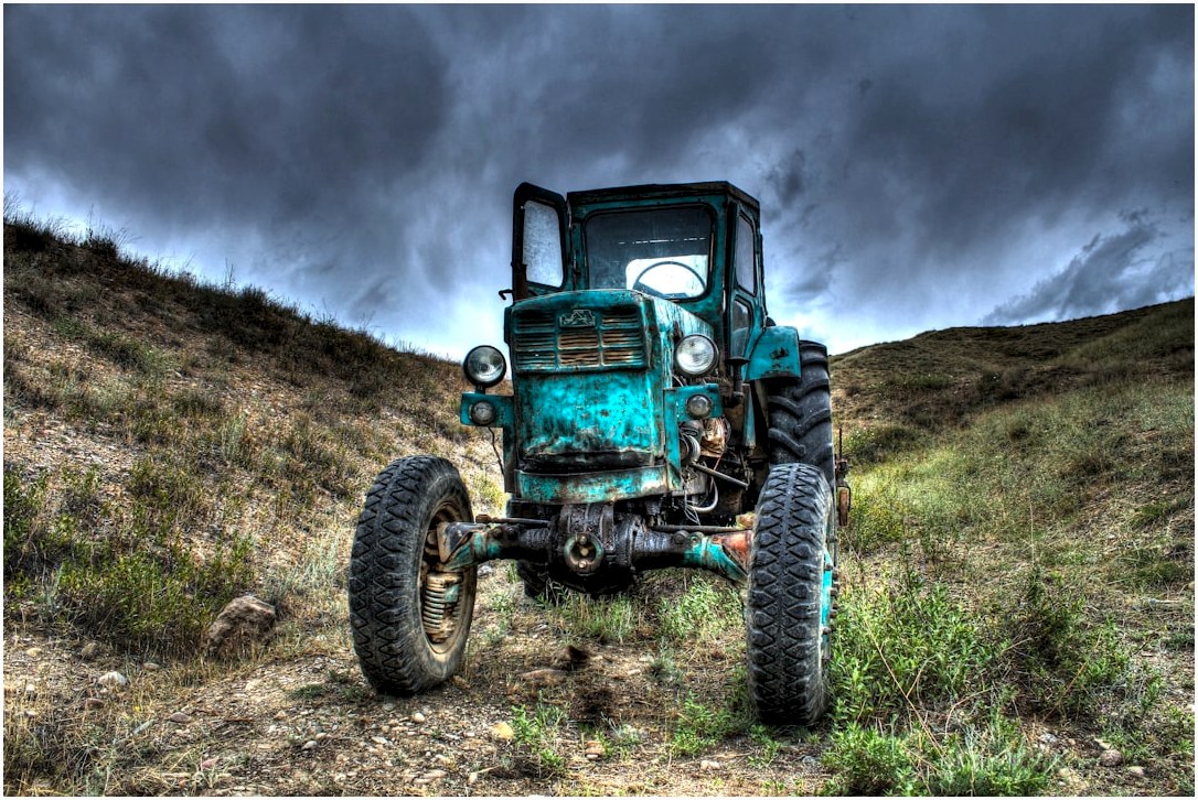 an old truck sitting in the middle of a field