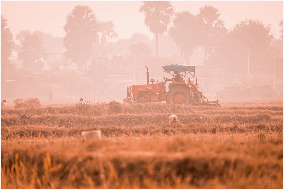 a tractor is driving through a field in the fog