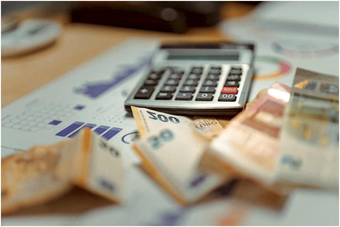A calculator sitting on top of a pile of money