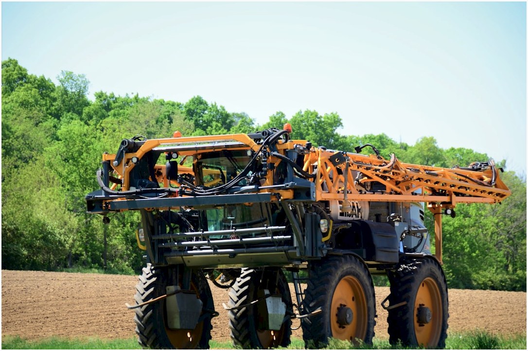 a tractor with a crane attached to it in a field