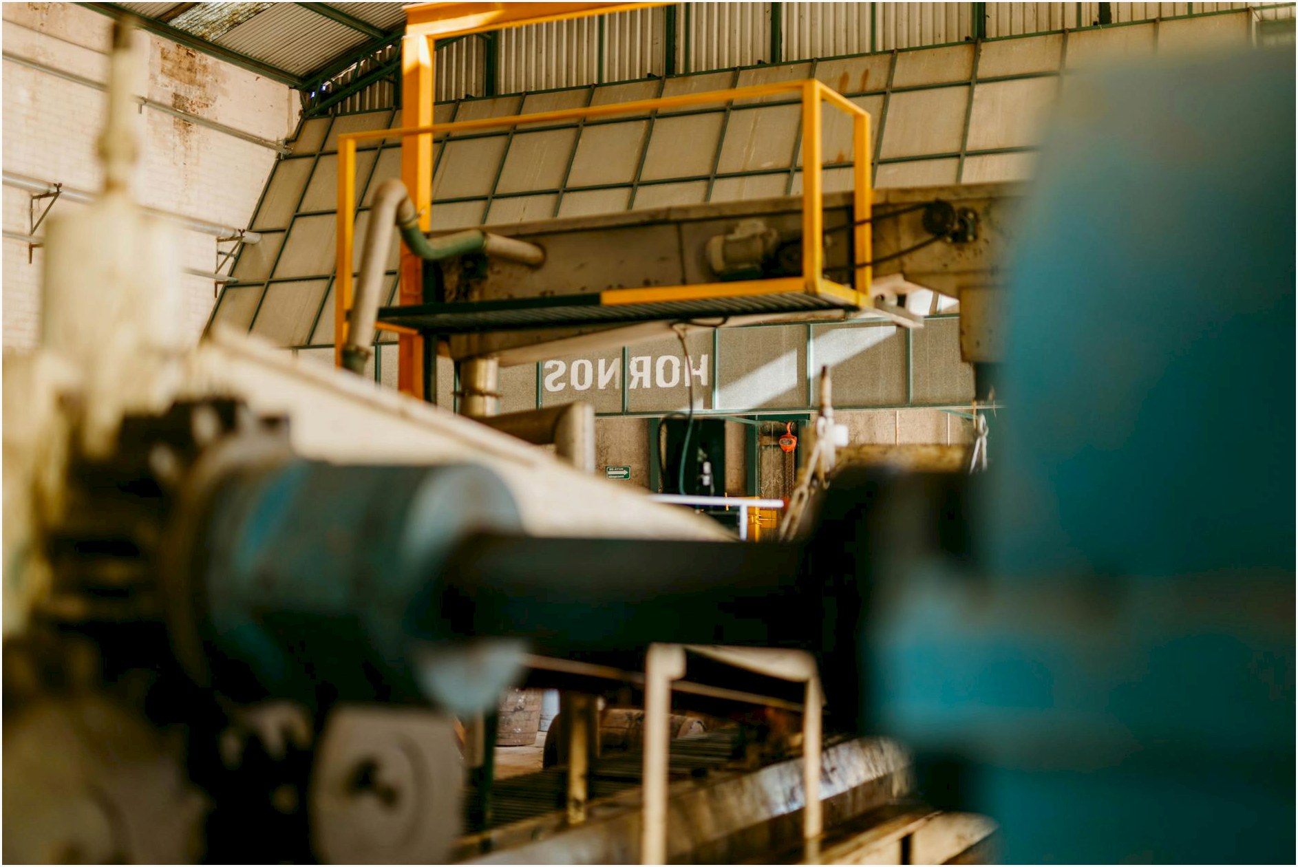 Close-up of heavy machinery inside an industrial factory with focus on ironworks and conveyor systems.