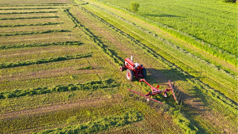 Trator trabalhando em área agrícola afetada por condições de produção
