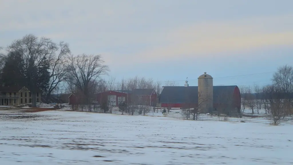 Propriedade rural com campo coberto de neve e galpões, imagem contextual sobre risco climático
