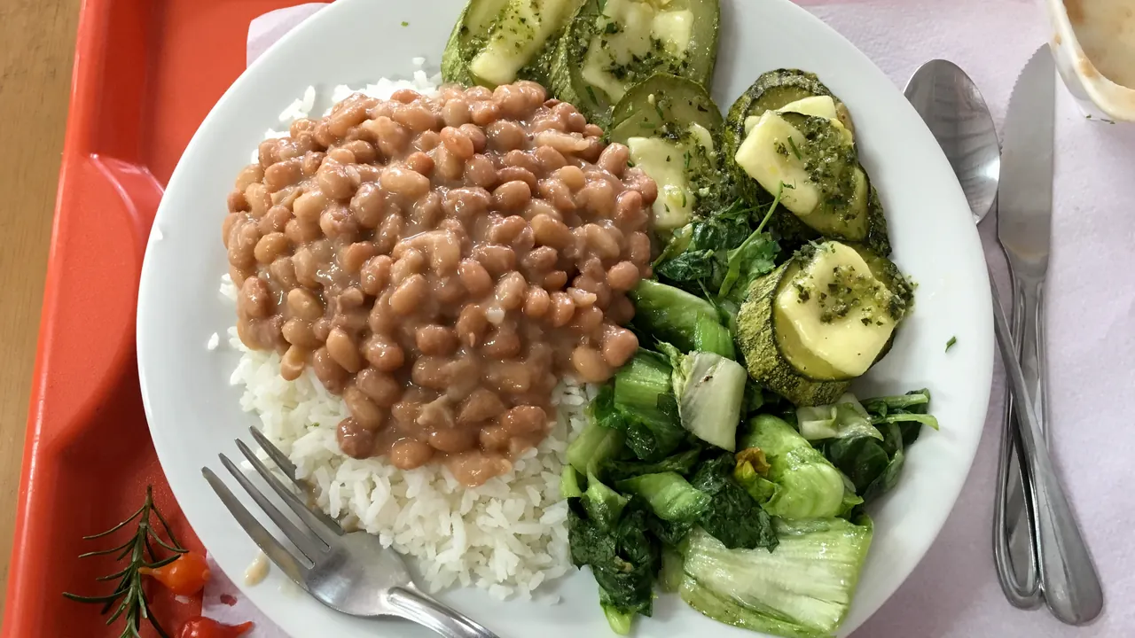 Arroz, feijão e hortaliças em um prato, imagem contextual ilustrativa sobre alimentos da agricultura familiar.
