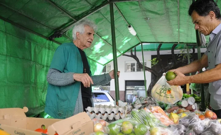 Feira do Programa Direto da Roça em Belo Horizonte com agricultor e cliente diante de hortaliças