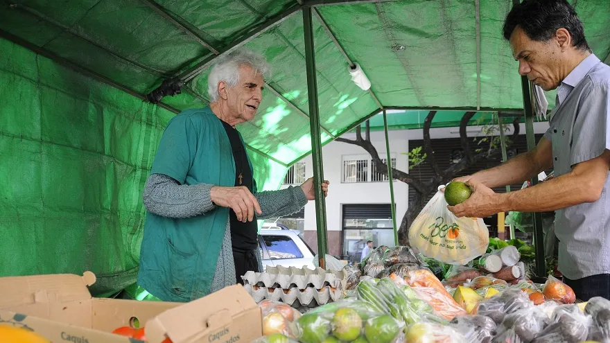 Feira do Programa Direto da Roça em Belo Horizonte com agricultor e cliente diante de hortaliças