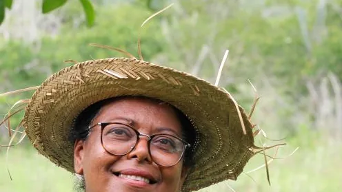 Agricultora familiar usando chapéu de palha em área rural