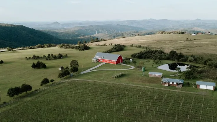 Vista aérea de propriedade rural com lavoura e casa de fazenda